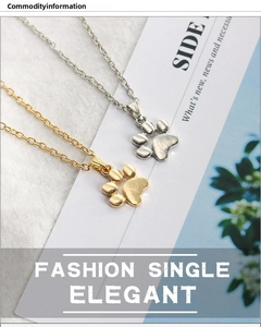 Detail view of gold and silver paw print necklaces on a textured background