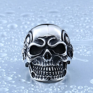 Gothic punk skull ring in silver stainless steel on a textured metallic water drop surface