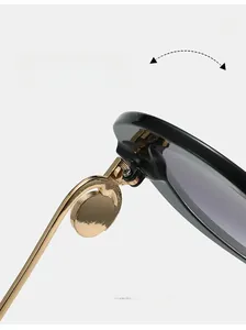 Detail of durable gold hinge and round metal nose pads on trendy black oval sunglasses