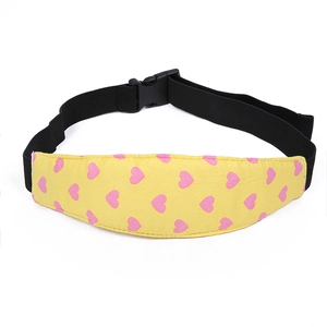 Detail of yellow baby stroller head support strap with pink heart pattern and buckle