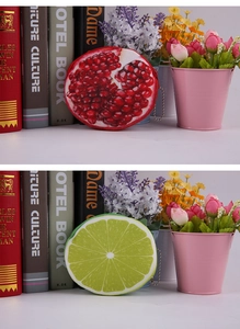 Detail of round plush coin purses with pomegranate and lime fruit patterns and bead chains