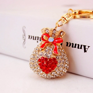 Sparkling crystal fortune bag keychain with red heart and gold-plated finish on book