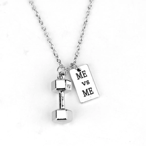 Silver dumbbell pendant necklace with ME vs ME engraved tag on a clean white background