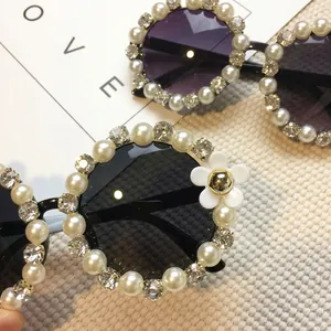 Women's round sunglasses with white pearls, rhinestones and floral accents on purple lenses
