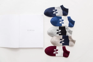 Dettaglio di cinque paia di calzini in cotone blu navy, nero e rosso con lettera N laterale