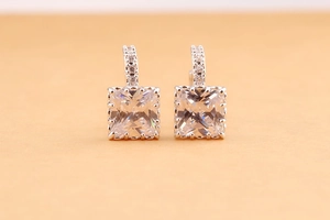 Macro shot of square-cut zircon hoop earrings with small stones in silver finish