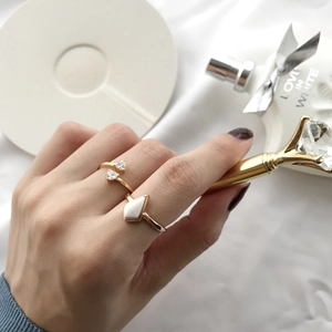 Detail of gold S925 rings with heart zircon and rhombus stone on elegant hand