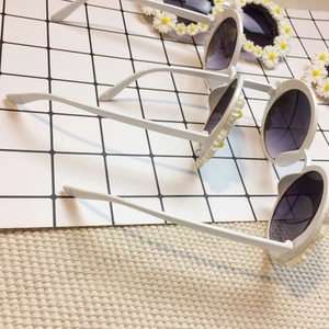Three white daisy-decorated round children's sunglasses with gradient grey lenses