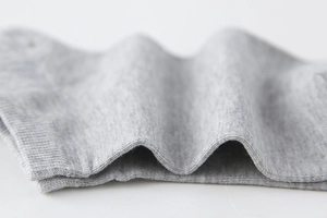 Macro della maglia in cotone grigio e polsino elastico a coste della calza invisibile uomo