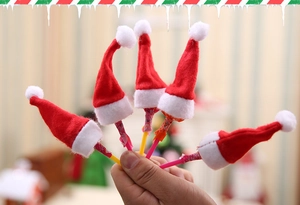 Close-up of five mini red plush Christmas hats for lollipops and cutlery decoration