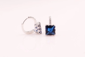 Detalle de circonitas azules cuadradas y pavé de diamantes en pendientes de aro de plata
