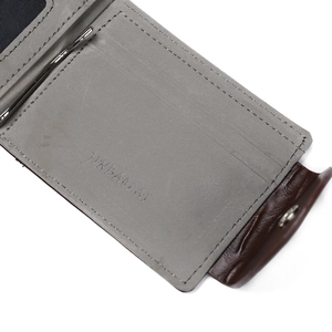 Macro shot of grey PU card slots with metal money clip and brown snap button closure