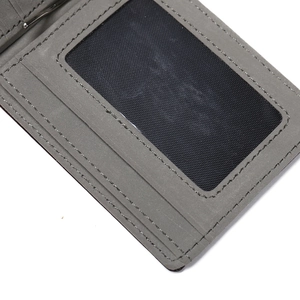 Detail view of grey frosted leather wallet featuring an ID window and metal money clip