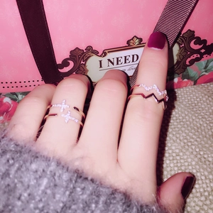 Detail of rose gold double-layer cross ring and wave band set with micro-inlaid crystals
