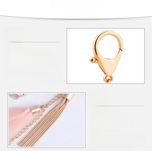 Dettaglio della chiusura a moschettone dorata con fiore in chiffon rosa e nappe