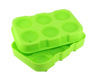 Detail of two stacked green silicone molds with 6 spherical cavities for ice balls
