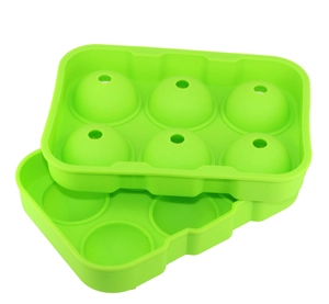 Detail view of a green 6-hole spherical silicone ice mold with a water injection lid
