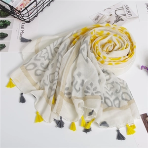 Detail shot of the cotton linen scarf showing yellow wave prints and fringe tassels