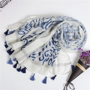 Close-up of blue and white wave pattern scarf with delicate cotton tassel details