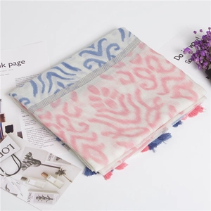 Close-up of lightweight cotton linen shawl with blue and pink ethnic patterns and fringe