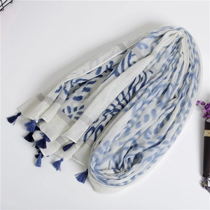 Detail showing high-contrast blue abstract prints and navy blue fringe on cotton-linen scarf