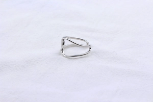 Macro shot of silver S925 sterling silver ring with minimalist wavy double-line design