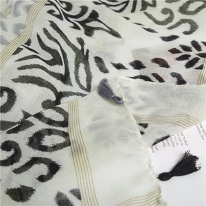Detail of bohemian scarf with leopard and zebra print, gold lines, and fringe trim