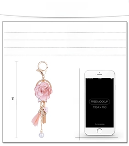 Portachiavi con rosa di stoffa rosa, nappe dorate e confronto dimensioni con telefono