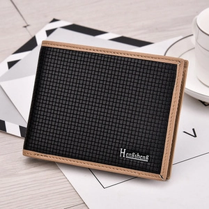 Vue détaillée du portefeuille tissé noir avec logo métallique sur une surface en bois
