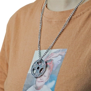 Gros plan du pendentif disque d'haltère en argent avec gravure fitness motivante