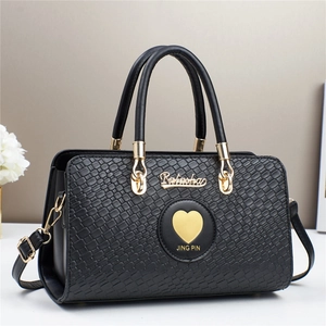 Detail of black woven texture handbag with golden Ratashas logo and heart charm detail