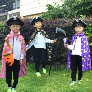 Three children outdoors wearing reversible Halloween cloaks with pirate and witch accessories