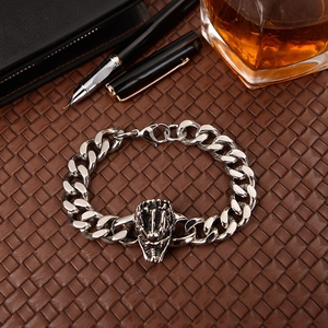 Close-up of a silver beast head sculpture on a chain bracelet in a luxury business setting