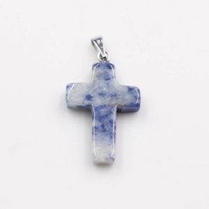 Macro shot of natural blue and white stone cross pendant with silver bail connector