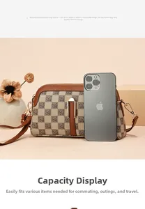 Detail of checkered crossbody bag with floral accents shown next to a phone for size reference
