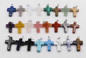 Macro shot of 24 colorful natural stone cross pendants with various textures and finishes