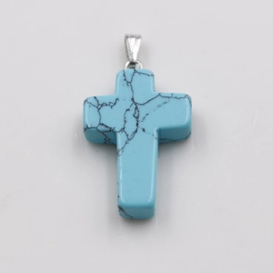 Detailed view of a blue stone cross pendant with black veins and silver metal clasp