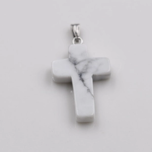 Macro detail of a white natural stone cross pendant with grey marble texture and silver bail