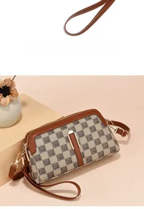 Close-up of brown checkered pattern handbag with gold zipper and leather strap detail