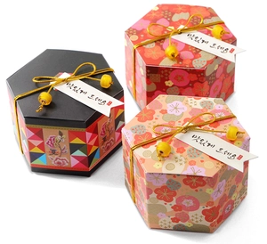 Detailed view of hexagonal gift boxes with gold cord and Korean style floral patterns