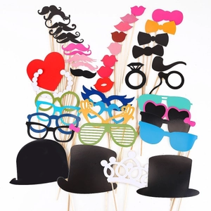 Collection of colorful paper photo booth props with mustaches and hats on wooden sticks