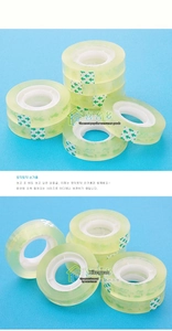 Macro shot of clear stationery tape rolls with green start stickers on blue surface