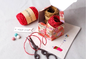 Macro shot of red floral hexagonal candy boxes with natural hemp rope for DIY gift packing