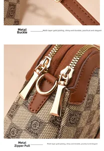 Detailed close-up of gold-plated hardware and dual zippers on a vintage-style handbag