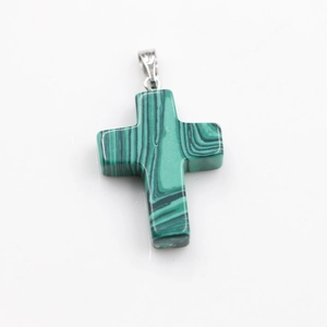 Detail of green malachite cross pendant with black texture and silver metal bail