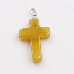 Macro shot of yellow natural stone cross pendant with silver loop on white background