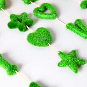 Detail of green flocked heart and star hanging ornaments with soft fuzzy texture