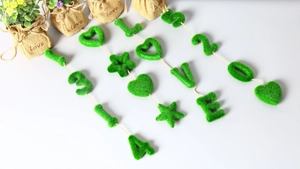 Detail of green flocked moss wall decor featuring heart shape and rustic jute twine