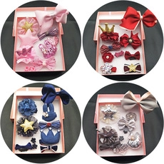 Close-up of children's hair accessories gift set featuring bows and crowns in a box