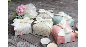 Close-up of vintage floral and polka dot gift boxes with elegant white ribbon bows